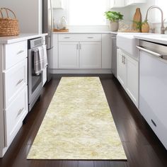 a clean kitchen with white cabinets and wood flooring is seen in this image from the doorway