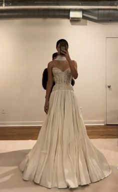 a woman in a wedding dress taking a selfie