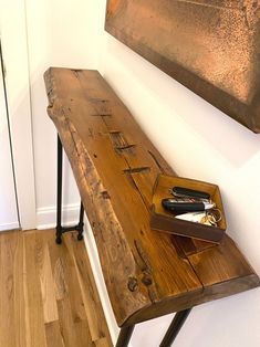 a wooden bench sitting on top of a hard wood floor next to a metal frame