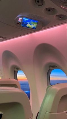 the inside of an airplane looking out at the ocean and sky with its lights on