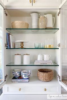 the shelves in this kitchen are filled with dishes, cups and other things to put on them