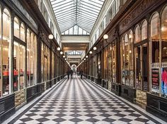 an empty shopping mall with people walking down the hall and on the other side of the walkway