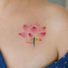 a pink flower on the back of a woman's shoulder is shown in this image