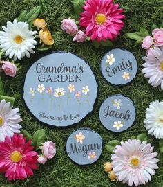 garden stepping stones with names and flowers on them sitting in the middle of green grass