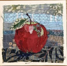 an apple is sitting on top of a piece of fabric and has been stitched together