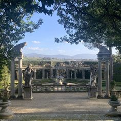 an outdoor garden with statues and trees