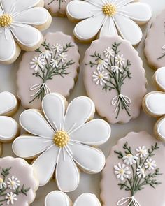 decorated cookies with white flowers and green stems on the top one cookie has been cut out to look like daisies