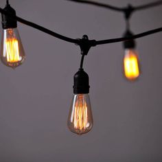 some light bulbs are hanging from a wire with lights on it and one is turned on