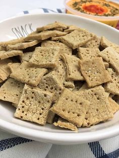 a white bowl filled with crackers on top of a blue and white table cloth