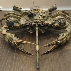 a model of a crab made out of metal parts on top of a wooden table