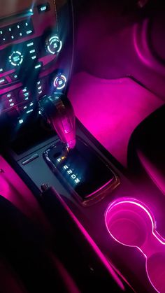 the interior of a car is lit up with purple light and features an illuminated steering wheel