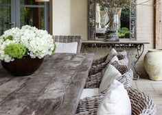 a wooden table topped with white flowers next to a mirror