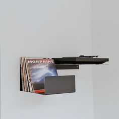 there is a shelf with magazines on it and a magazine rack attached to the wall