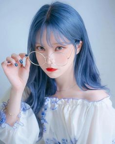 a woman with blue hair and glasses on her face