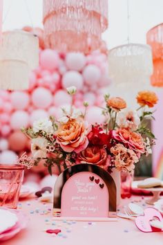 a table topped with lots of pink and orange flowers