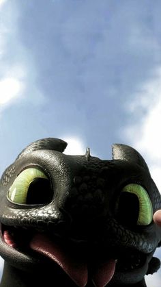 a close up of a toothless dragon with its tongue out and eyes wide open