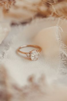 an engagement ring sitting on top of a white cloth