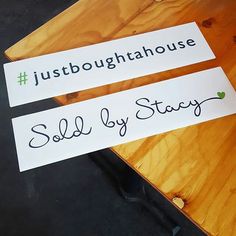 two signs that say, sold by stay and just bought at the house on top of a wooden table