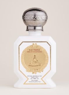 a white bottle with a gold emblem on the top that says eau trippie