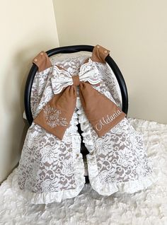 a baby crib with white and brown bedding on it