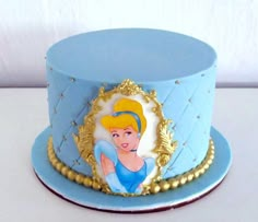 there is a blue and gold cake with a princess on it