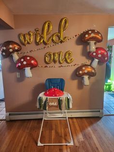 a birthday party with balloons and decorations on the wall, along with a chair in front of it that says wild one