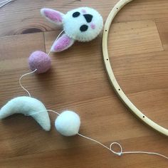 two small stuffed animals are next to a circular object on the floor with string attached