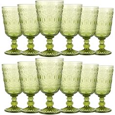 six green glass goblets are lined up on a white background, each with an ornate design