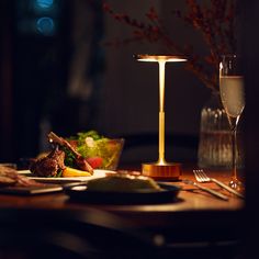 a table topped with plates and glasses next to a wine glass on top of a wooden table