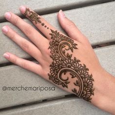 a woman's hand with henna tattoos on it