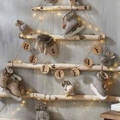 a christmas tree made out of branches with animals and letters hanging from it's sides