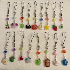 a bunch of different key chains that are on a white surface with some charms attached to them