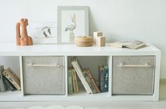 a white shelf with books and toys on it