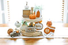 three tiered display with pumpkins and other decorations