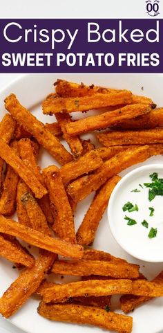 crispy baked sweet potato fries on a white plate with ranch dip and parsley