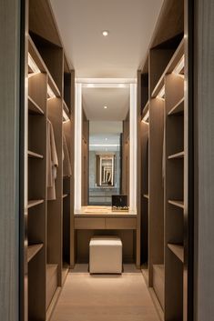 a walk - in closet with wooden shelves and lighting