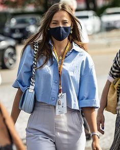 a woman wearing a face mask while walking down the street