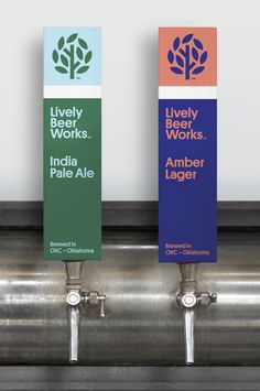 three beer taps with labels on them in front of a metal tank that says lively works india pale ale