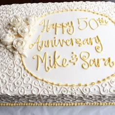 a 50th wedding anniversary cake with white and gold frosting