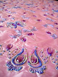 a pink table cloth with purple and blue designs on it