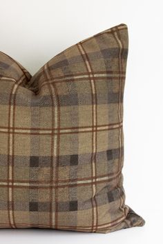 a brown plaid pillow sitting on top of a white wall