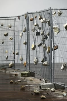 many rocks are on the ground behind a fence