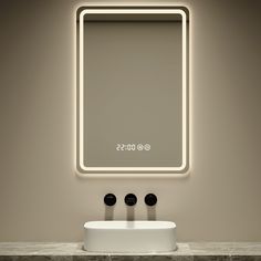 a bathroom sink with three black knobs under a lighted mirror and light above it