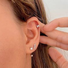 a close up of a person's ear with three small diamond studs