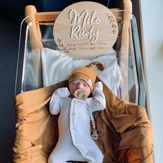 a baby in a wooden rocking chair wearing a brown hat and white onesie with the words mid - rocky on it