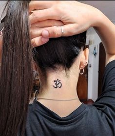 a woman with a small tattoo on her neck and behind her head is a ponytail