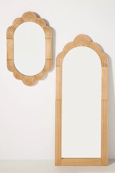 a wooden mirror sitting on top of a white counter next to a wall mounted mirror