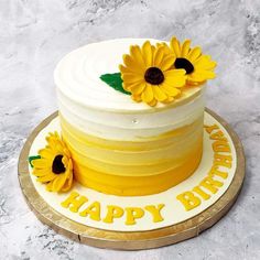 a white and yellow cake with sunflowers on top