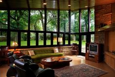 a living room filled with furniture and lots of large windows over the top of it