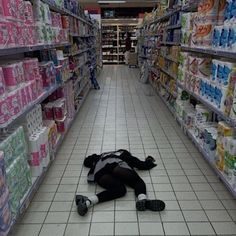 a person laying on the floor in a store aisle